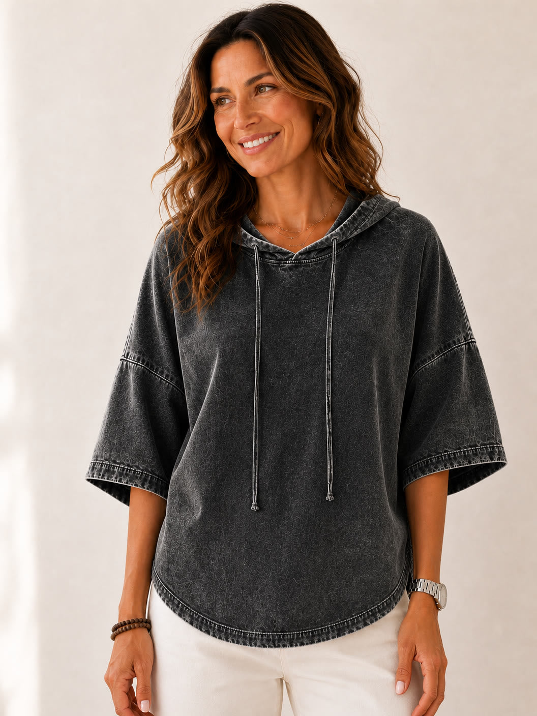 Woman wearing a LoomBasics washed grey 100% cotton hooded sweatshirt with wide sleeves.