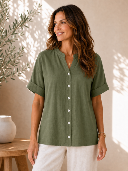 Woman wearing a LoomBasics v-neck 100% cotton olive green short sleeve blouse and white pants