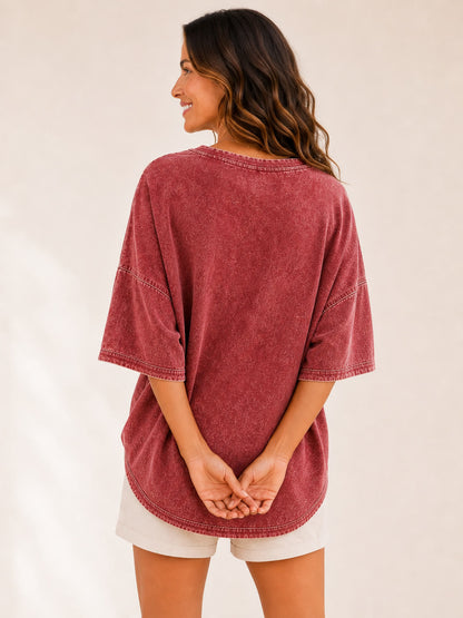 Back view of a woman wearing a LoomBasics washed red 100% cotton oversized blouse and white shorts