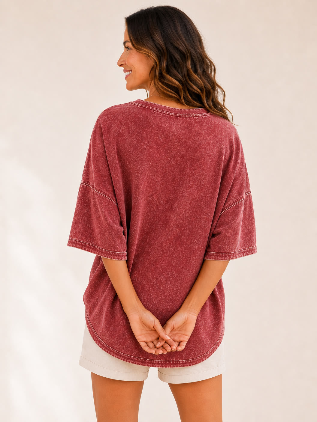 Back view of a woman wearing a LoomBasics washed red 100% cotton oversized blouse and white shorts