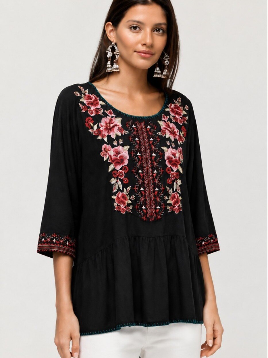 Woman wearing a black LoomBasics embroidered 100% cotton tunic shirt with red floral patterns.