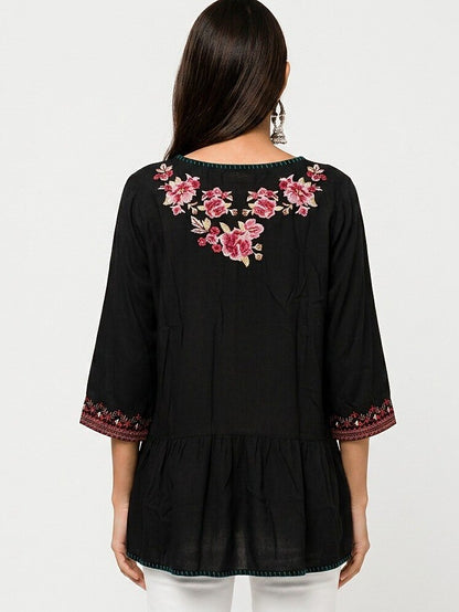 Back view of a LoomBasics black cotton tunic shirt with pink floral embroidery