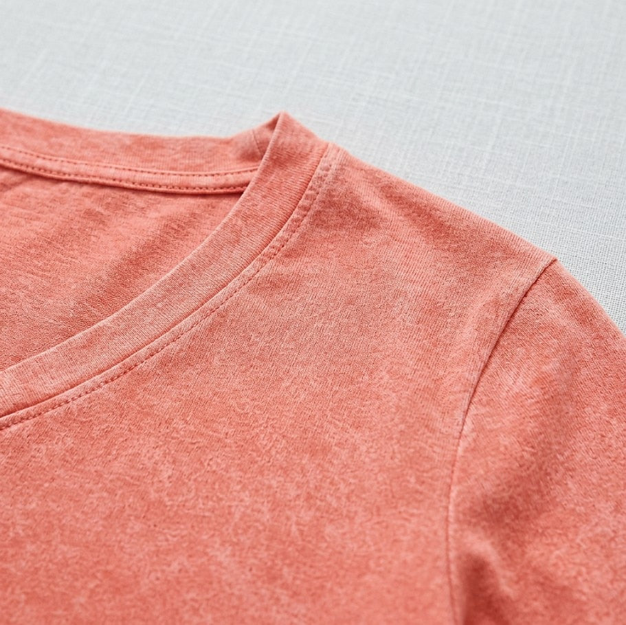Close-up of a washed 100% cotton V-neck top in a coral-pink color by LoomBasics.