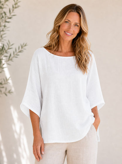 Woman wearing a white crew neck 100% cotton blouse by LoomBasics with beige linen pants.
